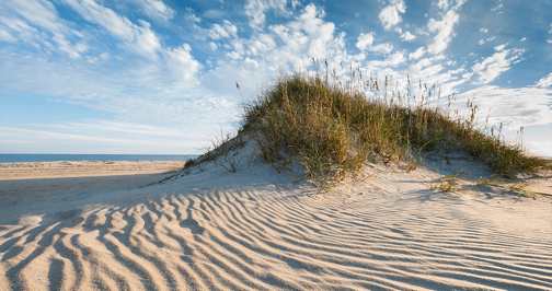 Currituck Beach Lighthouse peering over the edge of a Corolla sand dune. Photo Kip Tabb